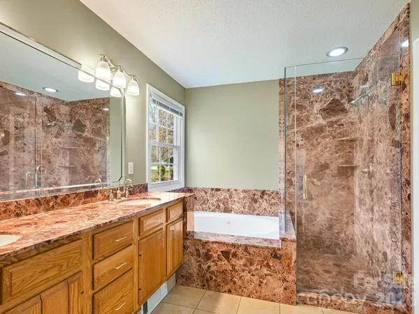 a bathroom with a granite countertop sink a mirror a and a shower