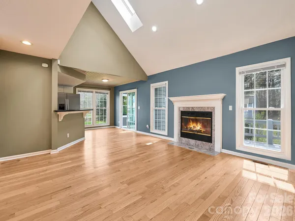 a view of an empty room with a window and fireplace
