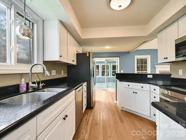a kitchen with stainless steel appliances granite countertop a sink stove and cabinets