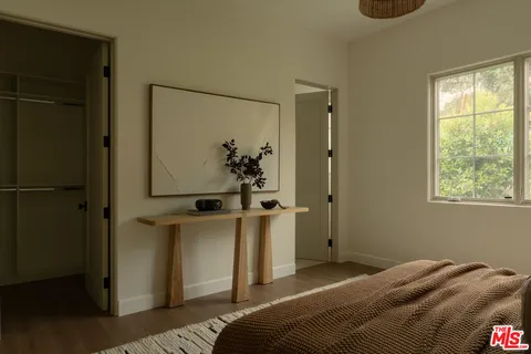 a bed sitting in a bedroom next to a window