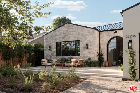 a front view of a house with sitting area and garden
