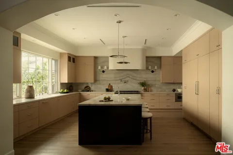 a kitchen with a sink appliances cabinets and a window