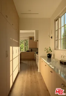 a large white kitchen with a large window