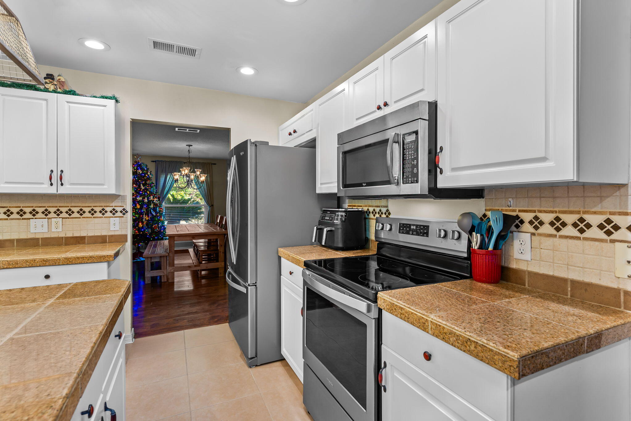 7373 Rexford Street Navarre, FL 32566 - Photo 14 of 56 a kitchen with stainless steel appliances granite countertop a stove and a refrigerator