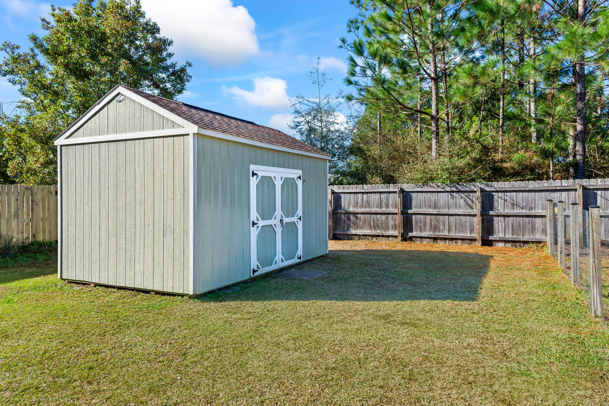 7373 Rexford Street Navarre, FL 32566 - Photo 51 of 56 a view of a backyard with wooden fence and large trees