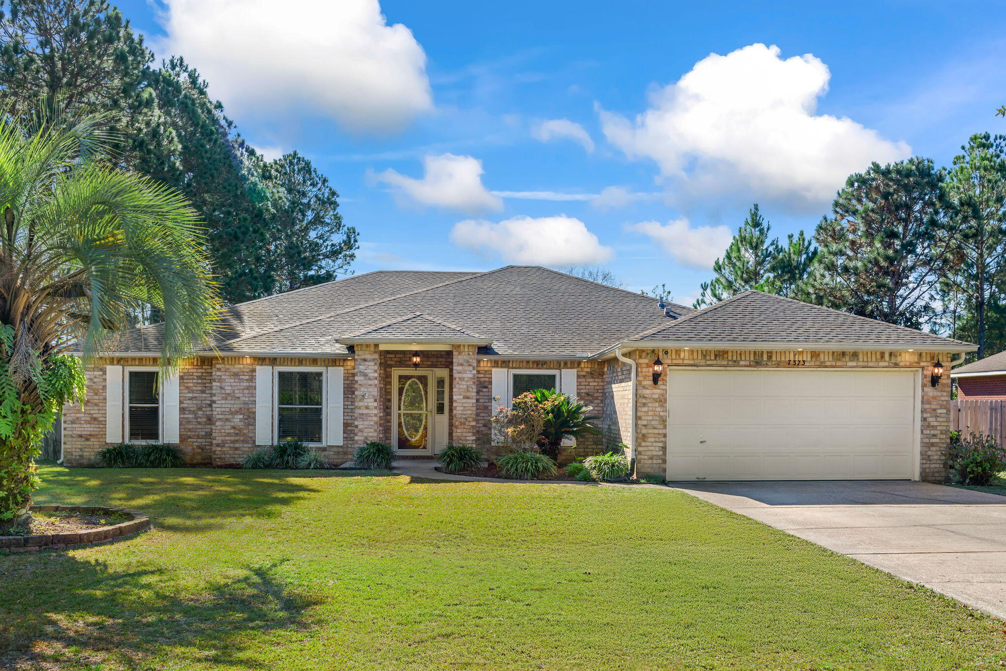 7373 Rexford Street Navarre, FL 32566 - Photo 52 of 56 a front view of a house with a garden and yard