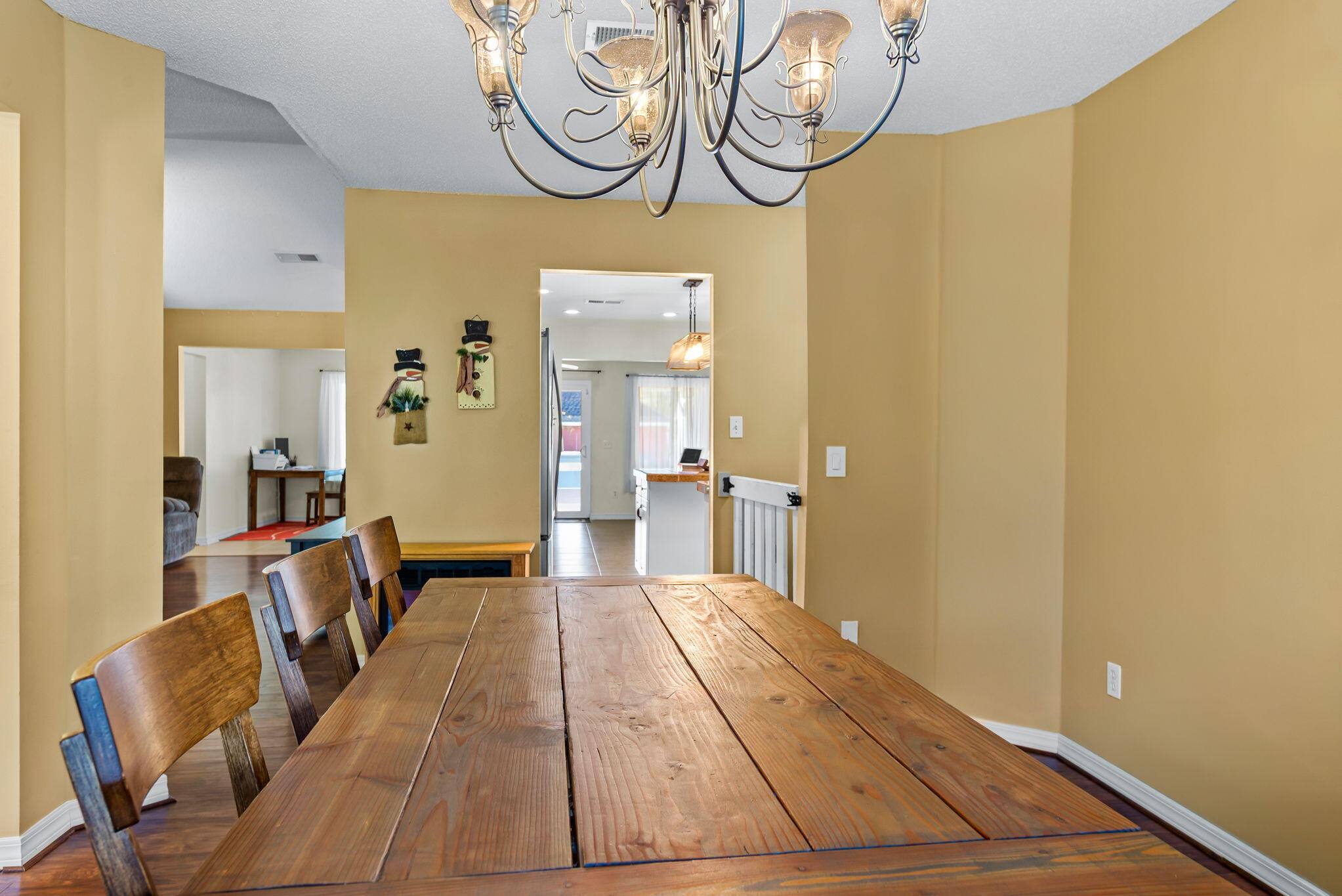 7373 Rexford Street Navarre, FL 32566 - Photo 9 of 56 a hallway with dining area and chandelier