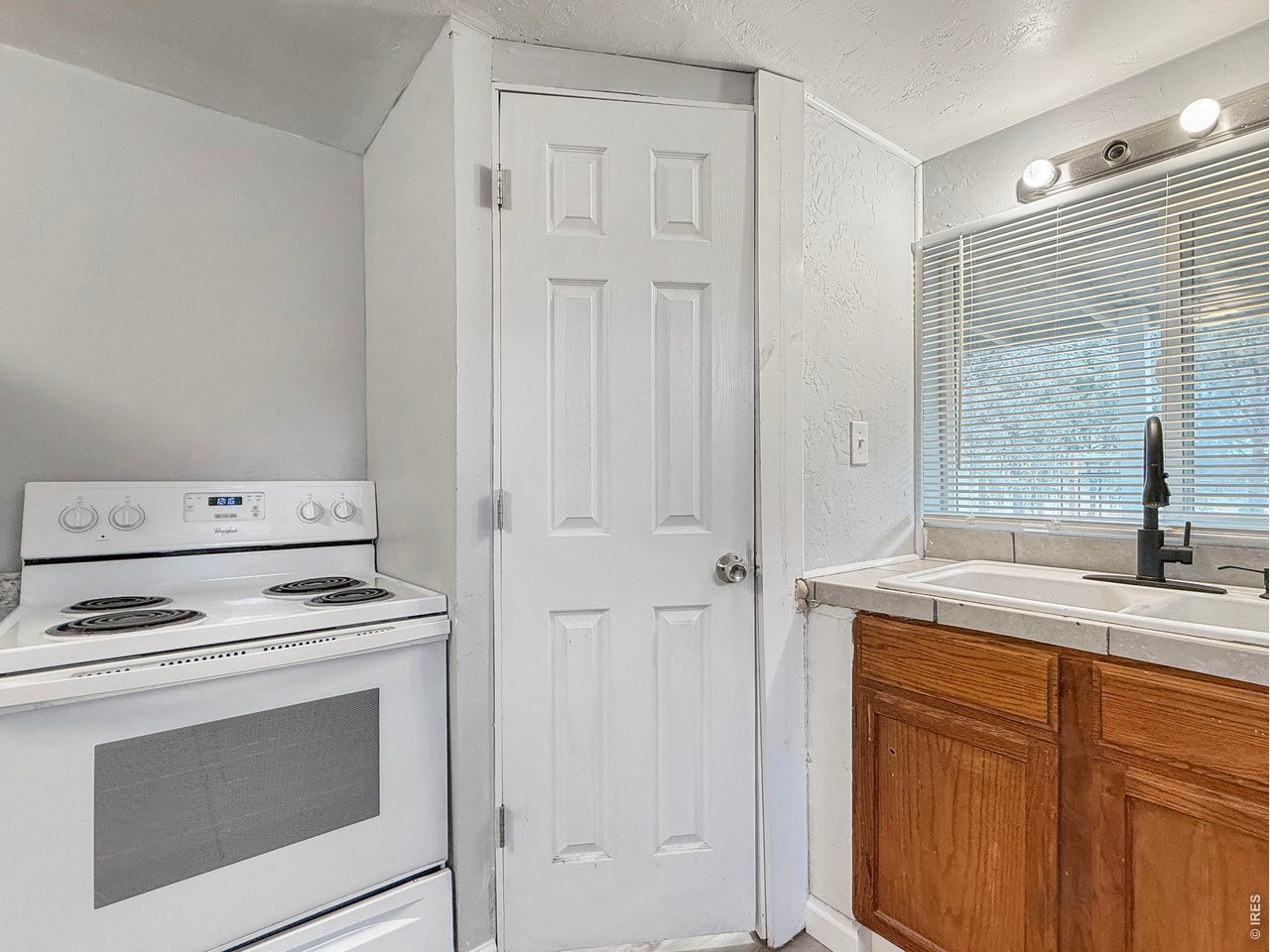 720 Phelps Street Sterling, CO 80751 - Photo 11 of 27 a kitchen with white cabinets and white appliances