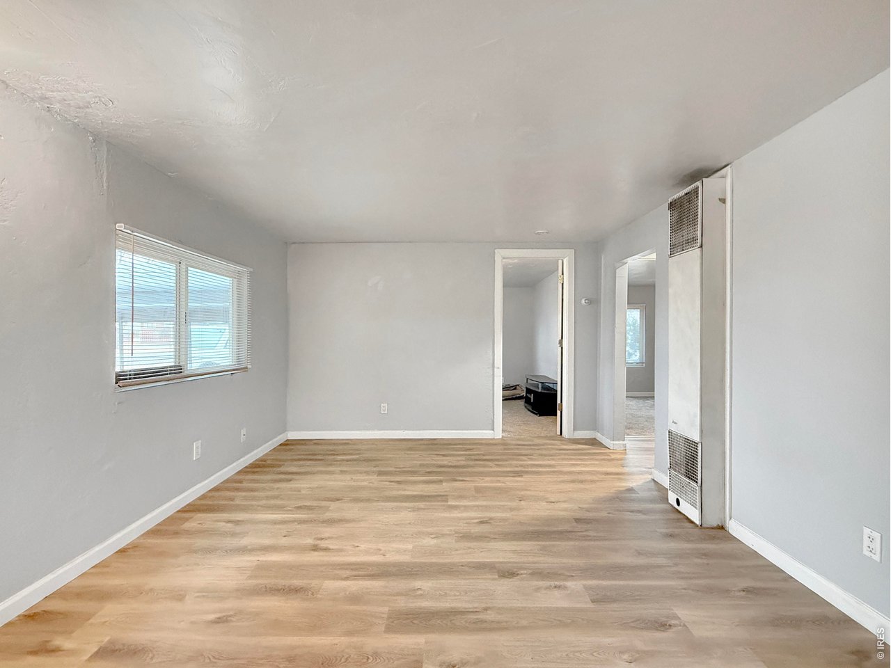 720 Phelps Street Sterling, CO 80751 - Photo 5 of 27 a view of an empty room with wooden floor and a window