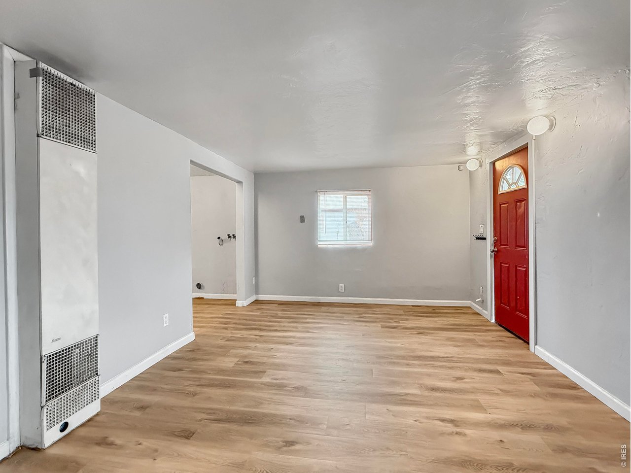 720 Phelps Street Sterling, CO 80751 - Photo 6 of 27 a view of an empty room with wooden floor and a window