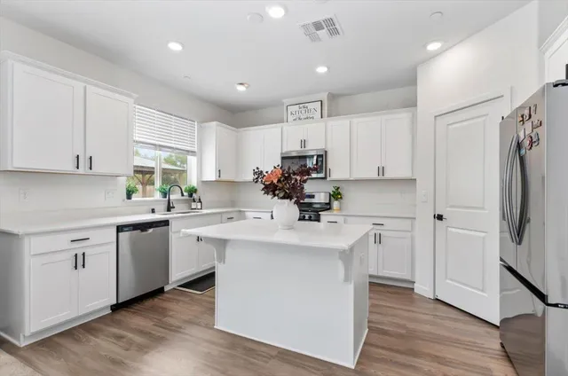 a kitchen with stainless steel appliances a stove refrigerator sink and microwave