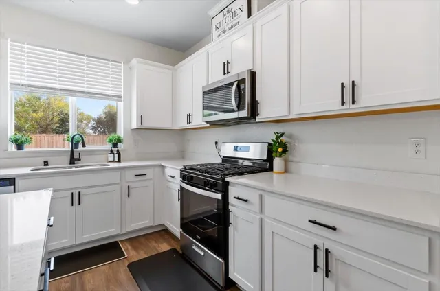 a kitchen with stainless steel appliances white cabinets and a sink