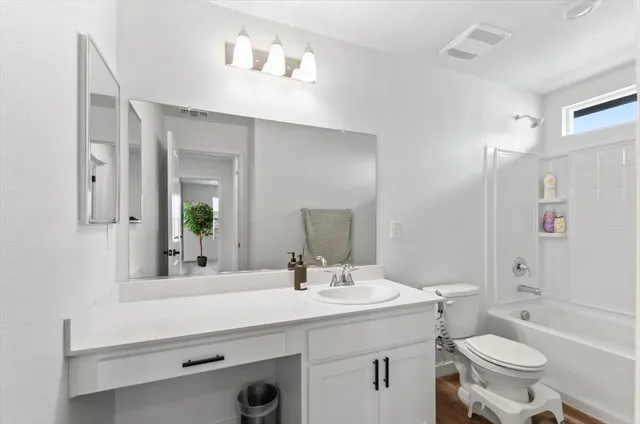 a bathroom with a toilet a sink a mirror and vanity