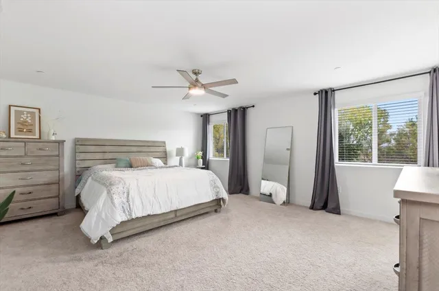 a bedroom with a large bed and a chandelier