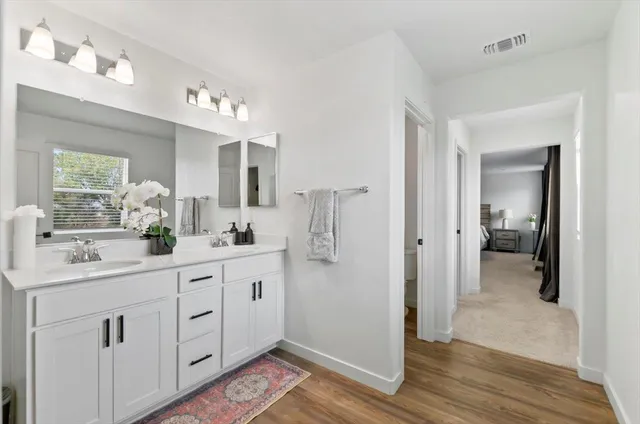 a spacious bathroom with a shower a sink and a mirror