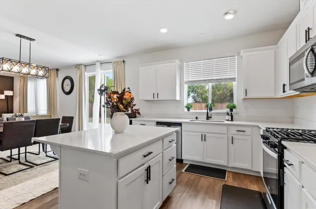 a kitchen with kitchen island a sink stainless steel appliances and cabinets