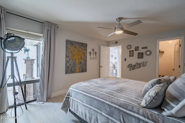 a bedroom with a bed chandelier and a window