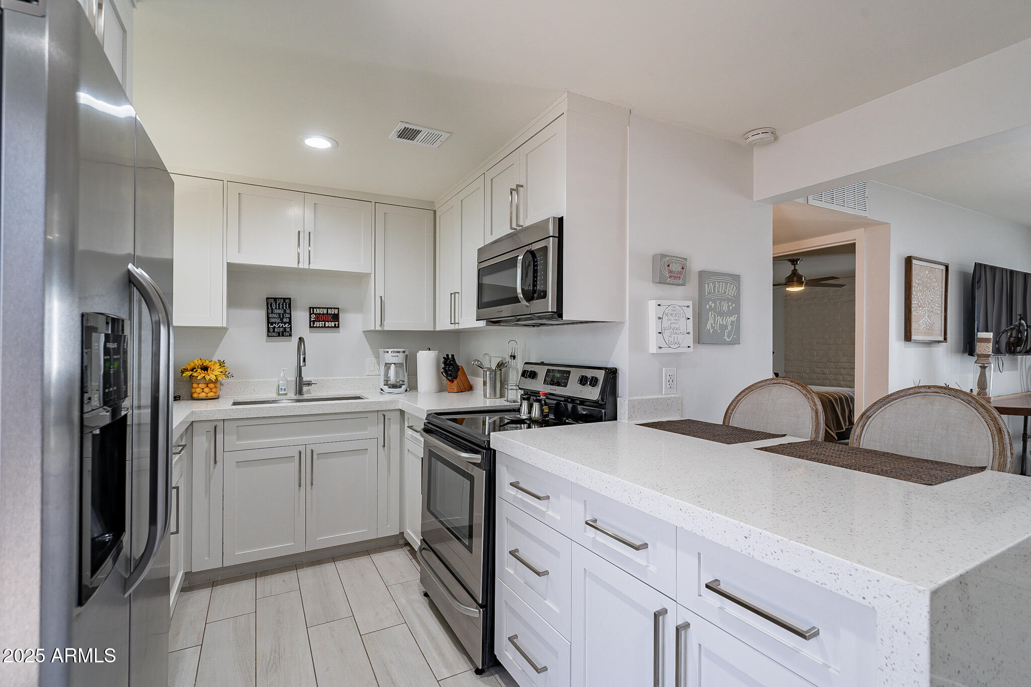 4351 North 36th Street, Unit 3 Phoenix, AZ 85018 - Photo 4 of 19 a kitchen with stainless steel appliances a sink a stove a refrigerator cabinets and a window