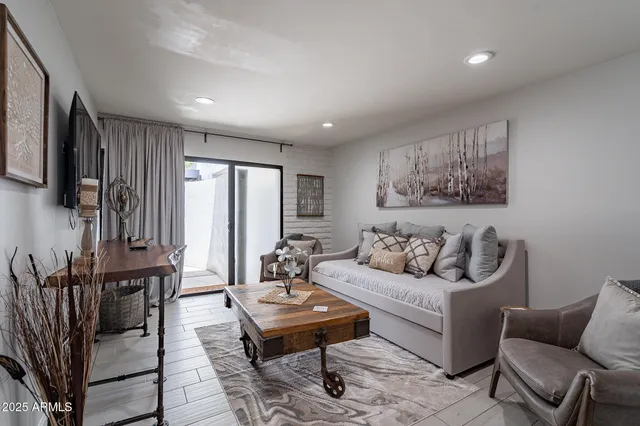 a living room with furniture a rug and a painting