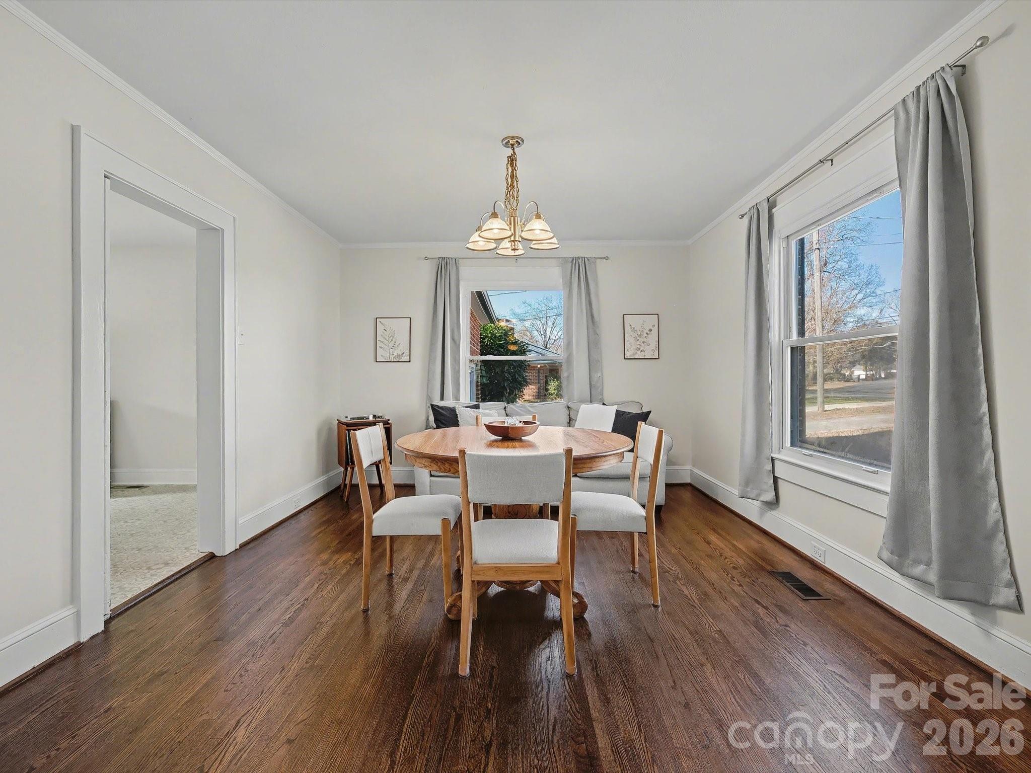 309 William Street Kannapolis, NC 28081 - Photo 6 of 38 a dining room with wooden floor a chandelier a wooden table and chairs