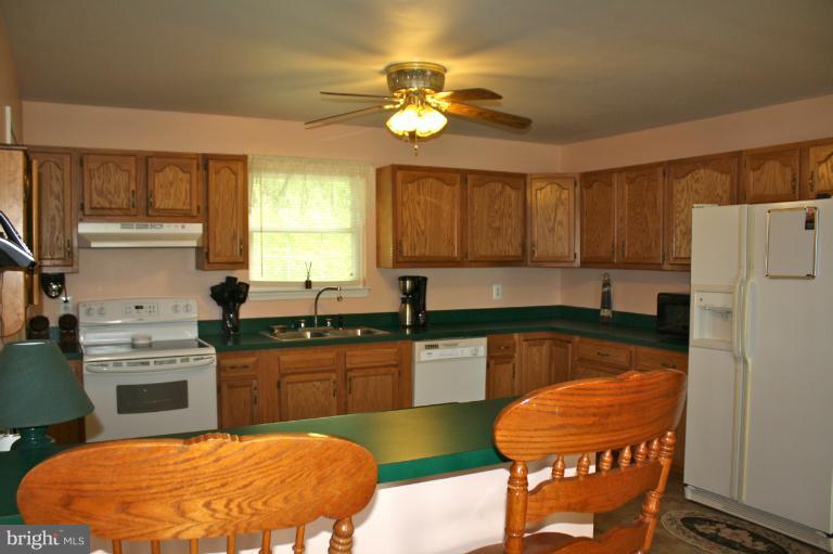 1950 Lowery Road Huntingtown, MD 20639 - Photo 15 of 28 a kitchen with stainless steel appliances granite countertop a chairs sink and cabinets
