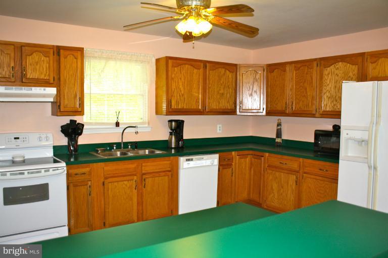 1950 Lowery Road Huntingtown, MD 20639 - Photo 16 of 28 a kitchen with stainless steel appliances granite countertop a sink a stove and a refrigerator