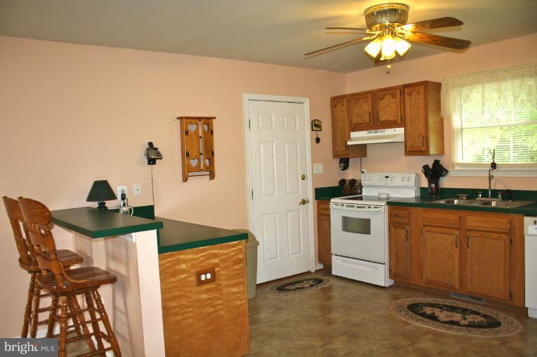 1950 Lowery Road Huntingtown, MD 20639 - Photo 18 of 28 a kitchen with stainless steel appliances granite countertop a sink a stove a refrigerator cabinets and dining table