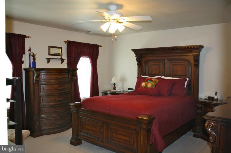 1950 Lowery Road Huntingtown, MD 20639 - Photo 19 of 28 a bedroom with a bed and a chandelier