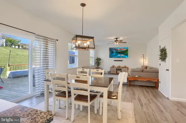 a living room with furniture a floor to ceiling window and a flat screen tv