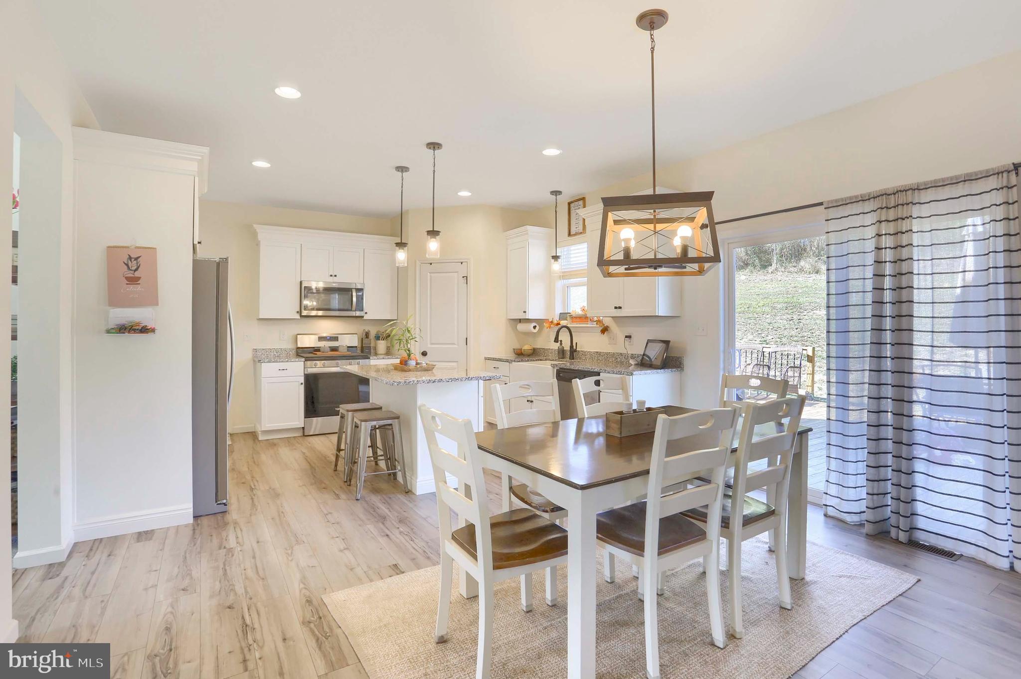 509 Elm Street Harrisburg, PA 17112 - Photo 14 of 41 a dining room with stainless steel appliances kitchen island granite countertop a dining table chairs and white cabinets