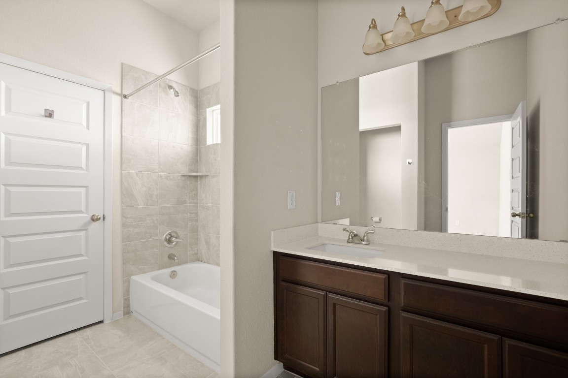 5601 Respinto Drive Austin, TX 78747 - Photo 11 of 17 a bathroom with a tub sink shower and two mirror