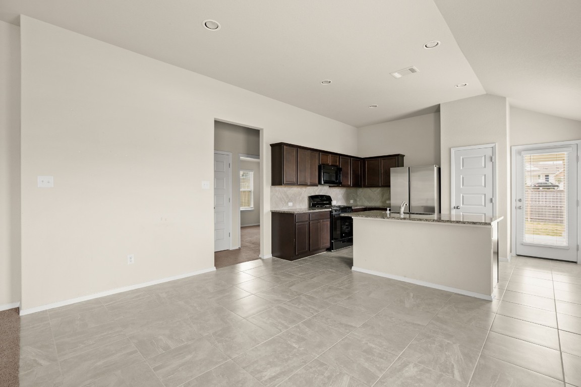 5601 Respinto Drive Austin, TX 78747 - Photo 6 of 17 a kitchen with stainless steel appliances a refrigerator and a stove top oven