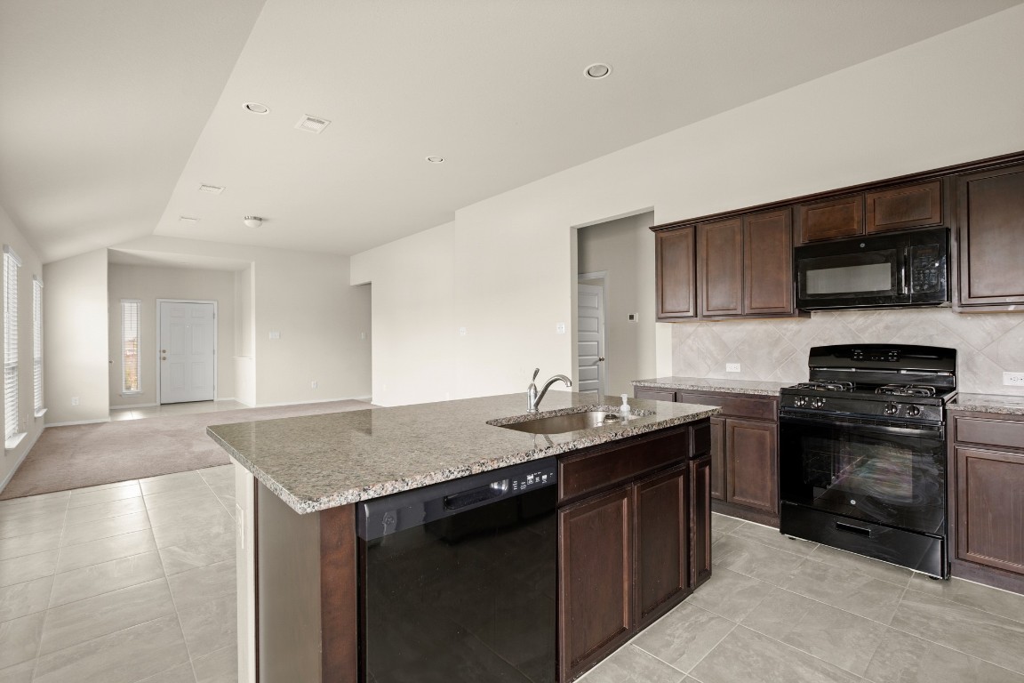 5601 Respinto Drive Austin, TX 78747 - Photo 7 of 17 a kitchen with stainless steel appliances granite countertop a sink stove and refrigerator