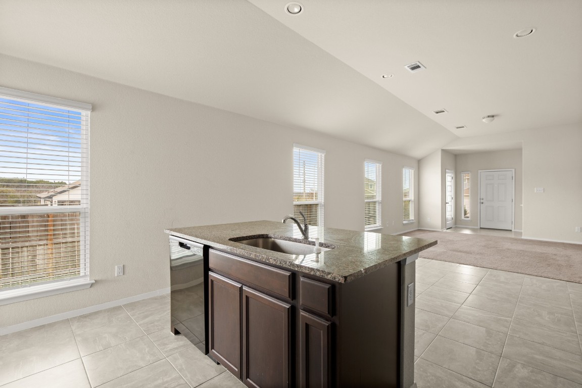 5601 Respinto Drive Austin, TX 78747 - Photo 8 of 17 a kitchen with granite countertop a sink and white cabinets