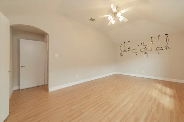 a view of a room with wooden floor and a ceiling fan