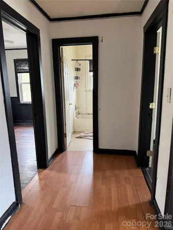 a view of a hallway with wooden floor and a living room