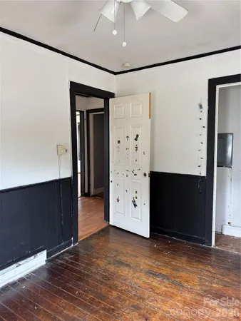 an empty room with wooden floor and cabinet