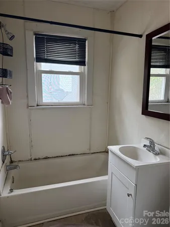 a bathroom with a bathtub a sink and a window