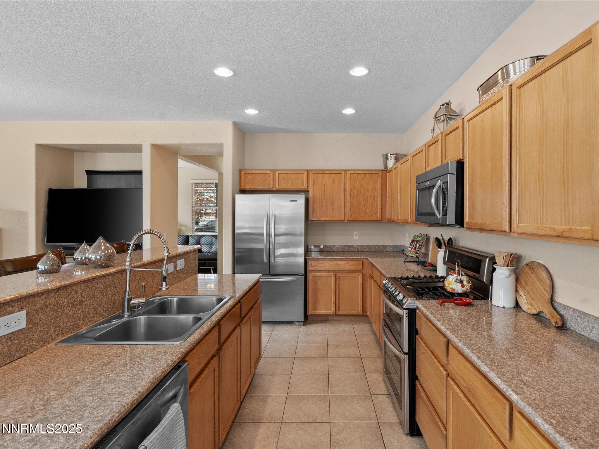 8934 Sorcha Street Reno, NV 89506 - Photo 16 of 60 a kitchen with kitchen island granite countertop a sink a counter top space appliances and cabinets