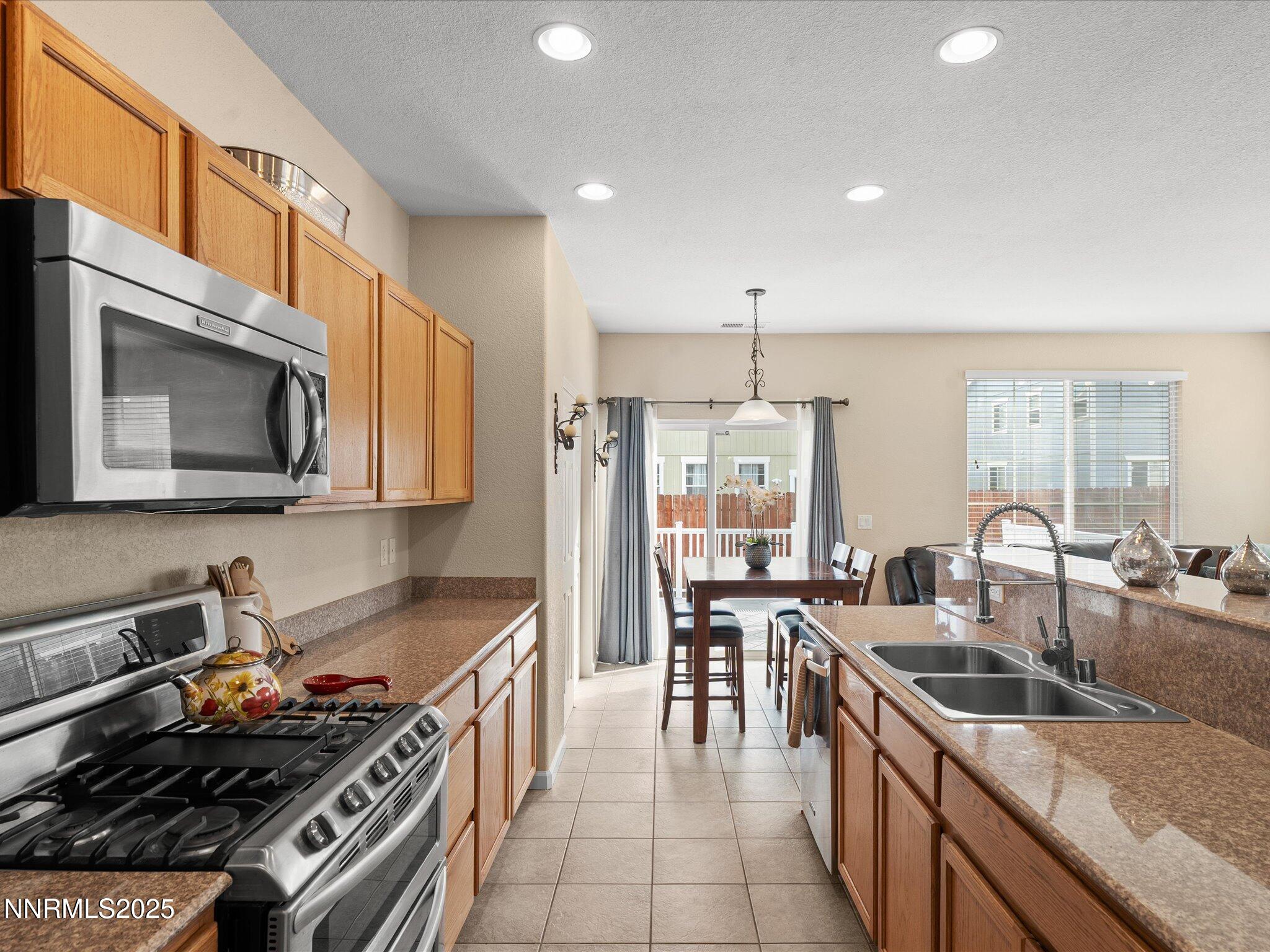 8934 Sorcha Street Reno, NV 89506 - Photo 18 of 60 a kitchen with stainless steel appliances granite countertop a stove a sink a microwave and a refrigerator