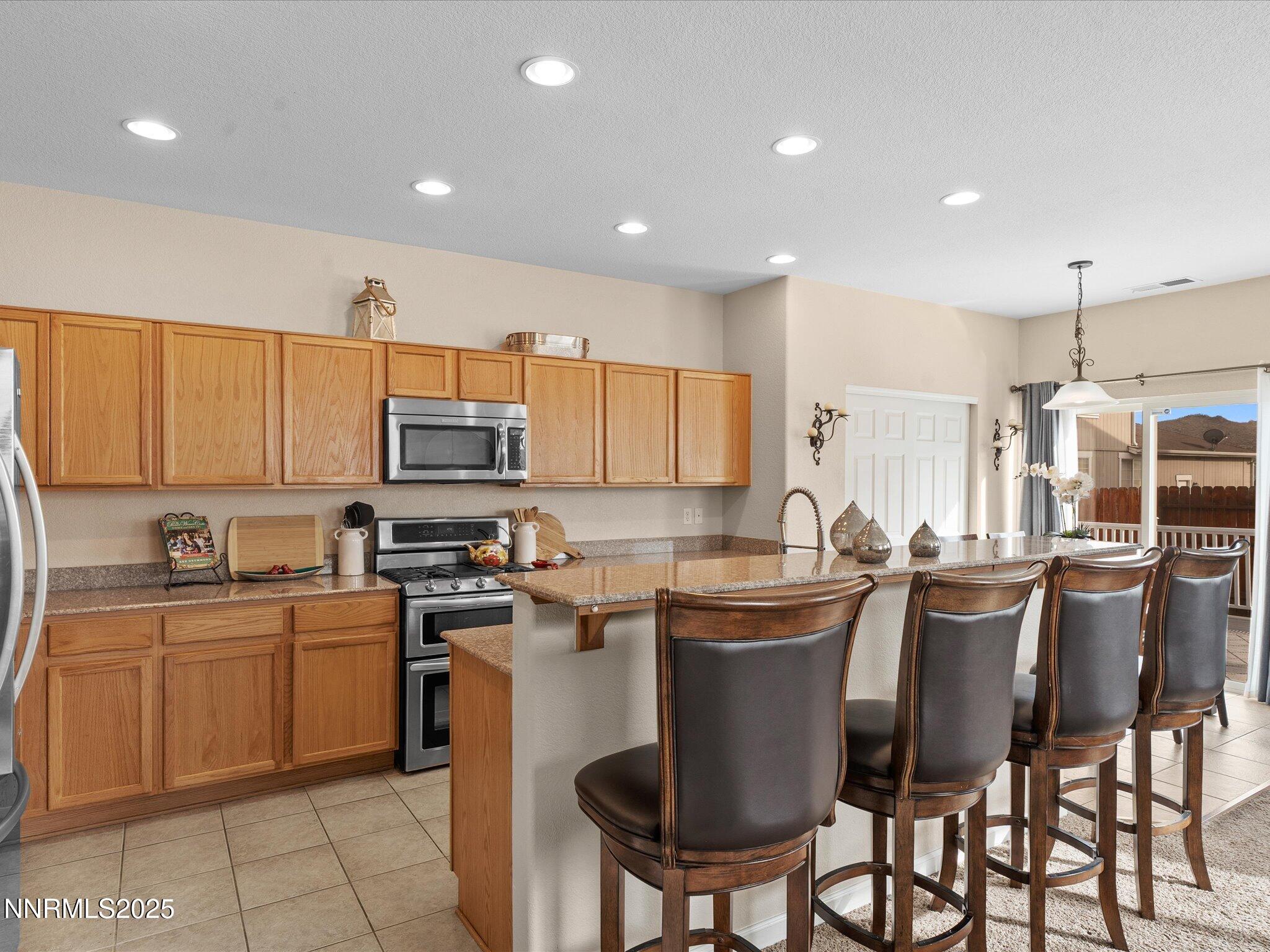 8934 Sorcha Street Reno, NV 89506 - Photo 20 of 60 a kitchen with appliances a sink a counter top space cabinets and a dining table