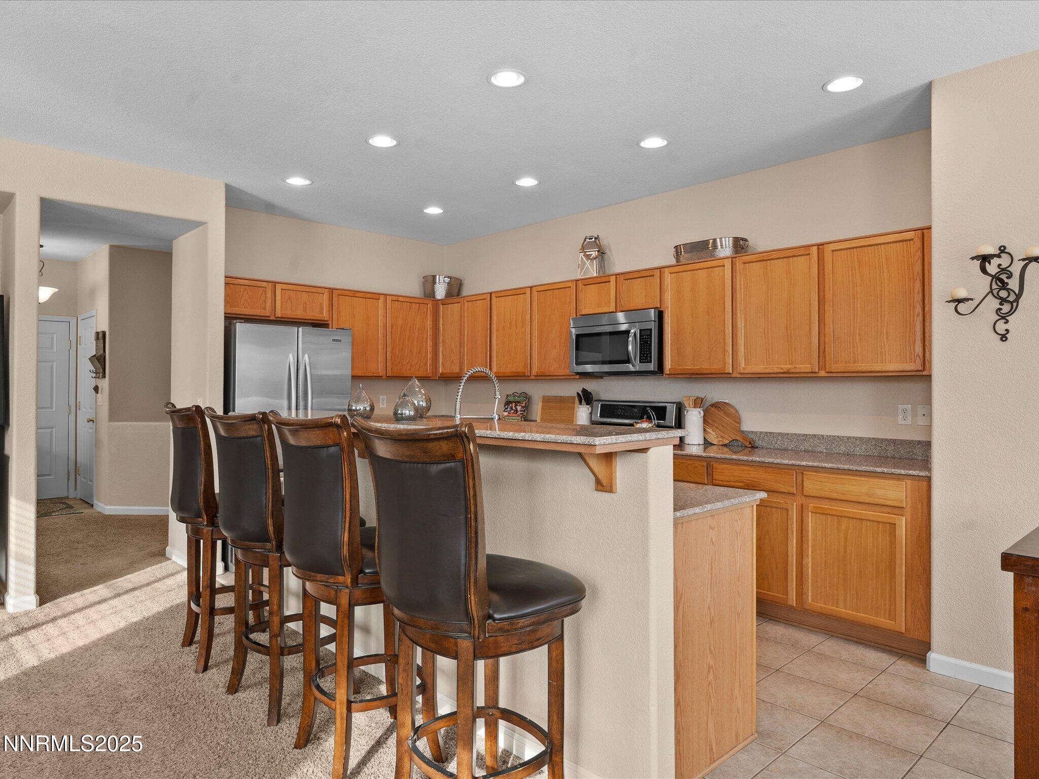 8934 Sorcha Street Reno, NV 89506 - Photo 22 of 60 a kitchen with stainless steel appliances granite countertop a table and chairs