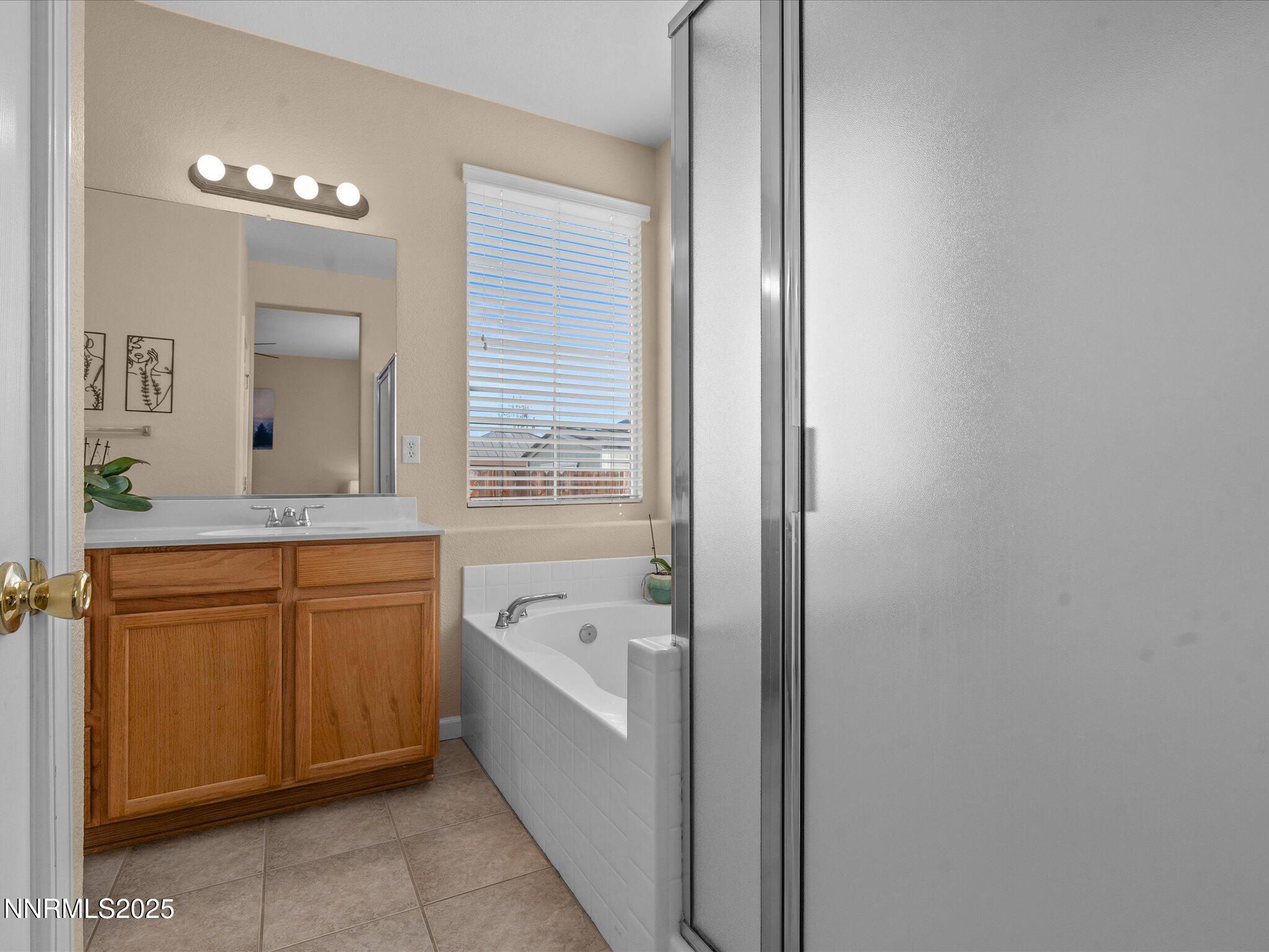 8934 Sorcha Street Reno, NV 89506 - Photo 25 of 60 a bathroom with a bathtub sink and mirror