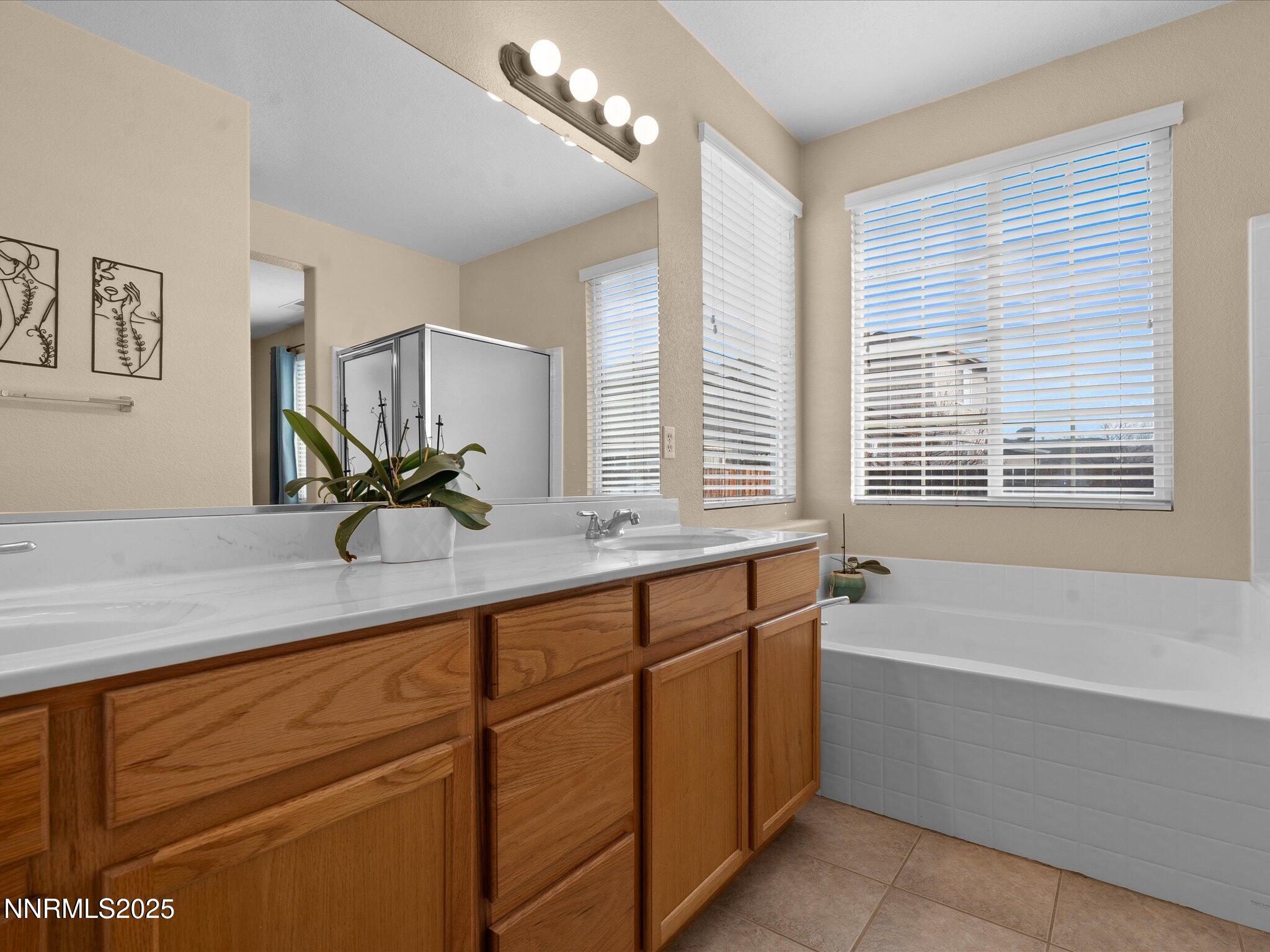 8934 Sorcha Street Reno, NV 89506 - Photo 27 of 60 a bathroom with a tub a sink and mirror