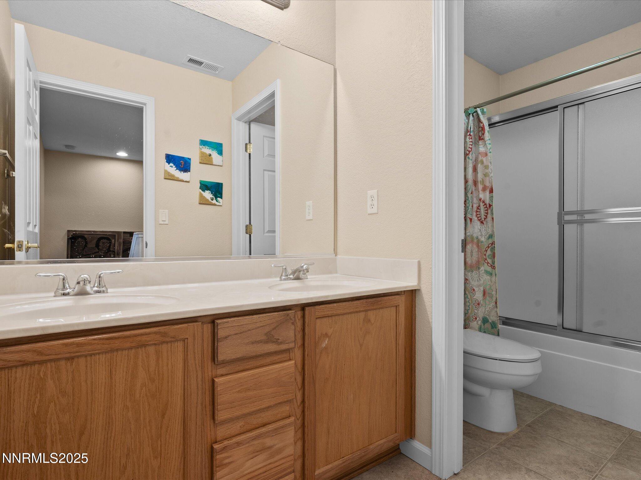 8934 Sorcha Street Reno, NV 89506 - Photo 41 of 60 a bathroom with a double vanity sink toilet and shower