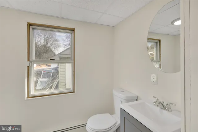 a bathroom with a toilet sink vanity and mirror