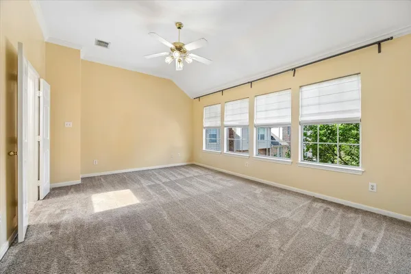 a view of an empty room with chandelier fan and fire place