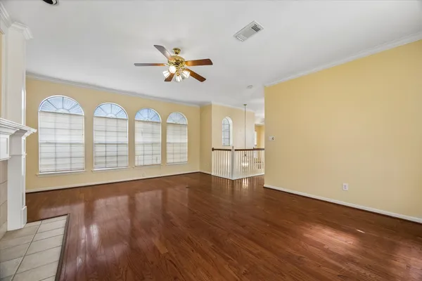 a view of an empty room with a window and wooden floor