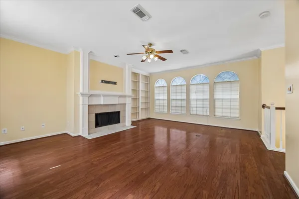 a view of an empty room with a window and wooden floor