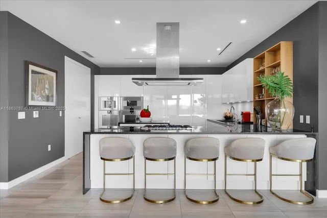 a kitchen with stainless steel appliances granite countertop breakfast area and windows